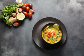 Tom Yam kung Spicy Thai soup with shrimp, seafood,tomatoes, mushrooms, lemongrass, coconut milk, ginger and chili pepper in bowl . Traditional Thai food