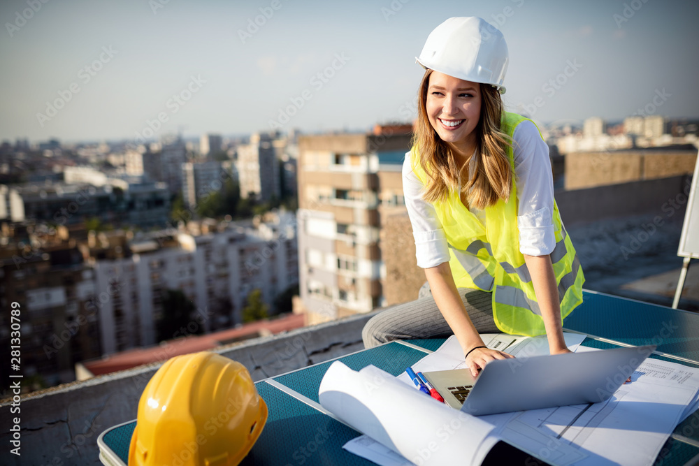 Wall mural young woman architect, construction engineer at a construction site