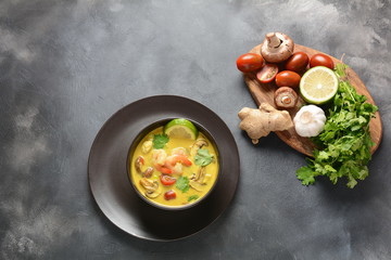 Tom Yam kung Spicy Thai soup with shrimp, seafood,tomatoes, mushrooms, lemongrass, coconut milk, ginger and chili pepper in bowl . Traditional Thai food