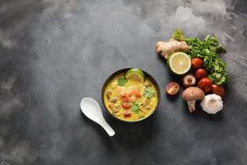 Tom Yam kung Spicy Thai soup with shrimp, seafood,tomatoes, mushrooms, lemongrass, coconut milk, ginger and chili pepper in bowl . Traditional Thai food