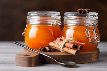 Jars with apricot jam on dark background