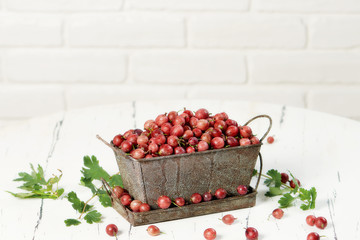 Gooseberries in basket on wooden background