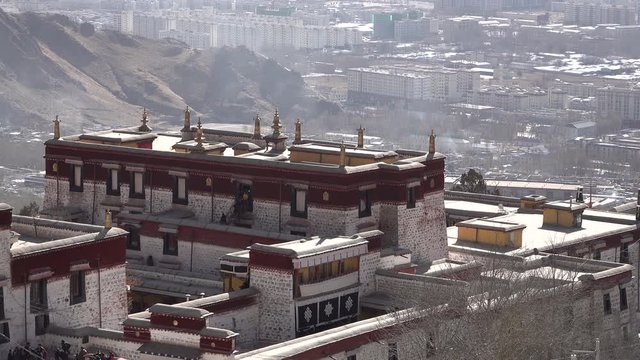 Contrast between building of Tibetan Drepung monastery (gompa) and residential towers in Lhasa