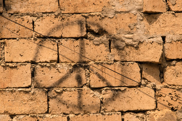 Grunge background of rustic bricks with sloppy mortar with spray painted peace sign and an electric wire running diagonally