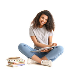 Portrait of cute African-American student on white background