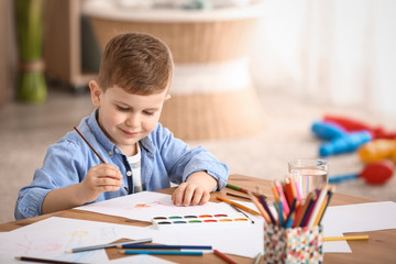 Cute little boy painting at home