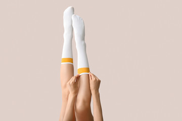 Legs of young woman in socks on light background