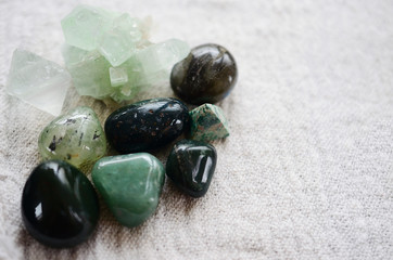 Lush green crystal collection, Green Quartz, Malachite, Peridot, Fluorite, rainforest jasper, and Quantum Quattro. Prosperity and abundance healing crystal collection. White background, bright colors