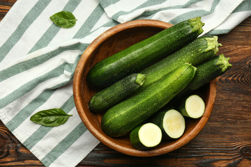 Bowl with fresh zucchini on table