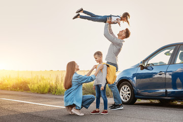 Parents saying goodbye to their children near car