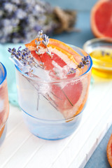 Glass with lavender lemonade on white board, closeup