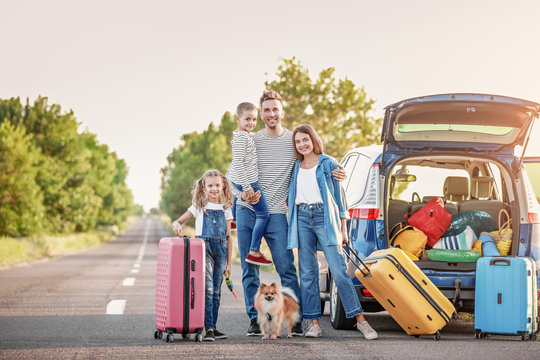 Happy family with luggage near car outdoors