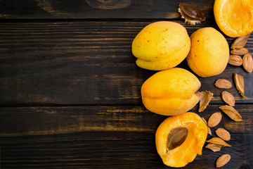 Apricots in a clay plate on a wooden table with broken bones. Food concept. top view