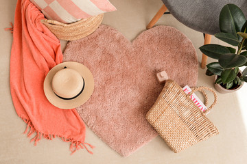 Fluffy carpet with plaid, female bag and hat on floor