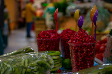 Vaso con granada roja junto a nopales picados, en mercado tradicional mexicano
