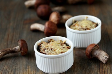 Julienne with forest mushrooms. Mushrooms are baked in cream and with cheese. Autumn leaves.
