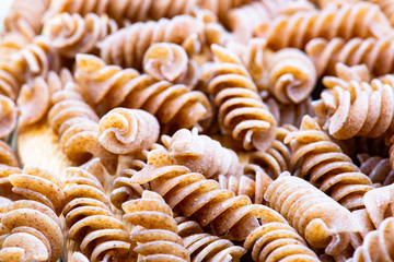 raw pasta with wooden spoons
