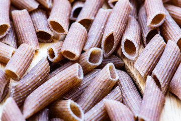 raw pasta with wooden spoons