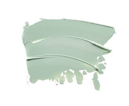 Gently green strokes and texture of face cream or acrylic paint isolated on white background