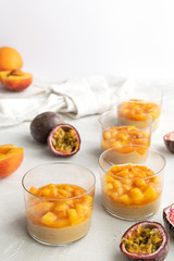 Caramel panna cotta, custard pudding with peach and passion fruit, white table, copy space