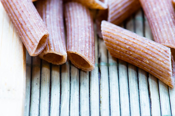 raw pasta with wooden spoons