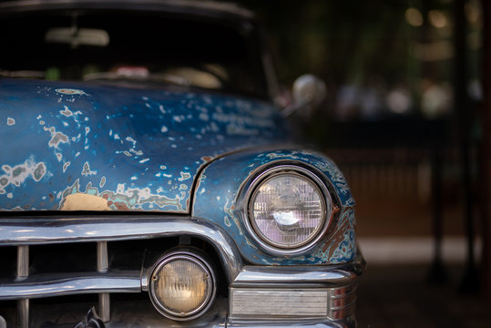 Frente de ve&iacute;culo antigo n&atilde;o identificado em exposi&ccedil;&atilde;o. Placa preta carro antigo em perfeito estado, detalhe do farol. Ve&iacute;culo necessita Funilaria e nova pintura descascado. Para restaurar