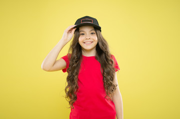 Comfy and cool. Girl long curly hair wear cap. Must have street style accessory trends. Modern fashion. Kids fashion. Girl cute child wear cap or snapback hat. Little girl wearing baseball cap