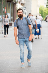 Guy exploring city. Comfortable tourism. Summer vacation. Sightseeing concept. Backpack for urban travelling. Hipster wearing backpack urban street background. Bearded man travel with backpack