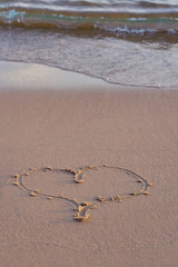 Heart written on sand on the beach. 