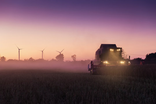 A harvesting machine on a field in sunset
