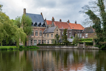 Fototapeta na wymiar A lake reflects the beautiful architecture on display in the quaint village of Bruges, Belgium