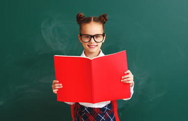funny child   schoolgirl girl student with book about school blackboard.