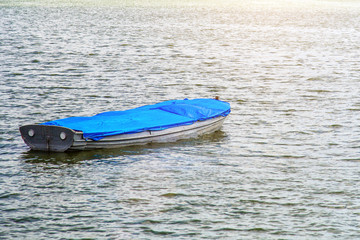 image of blue wooden fishing boat moored at the sea