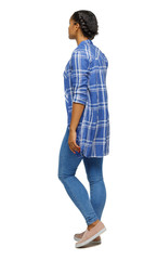 Side view of a young black girl walking in jeans and a checkered