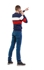 Naklejka premium Back view of pointing young men talking on cell phone.