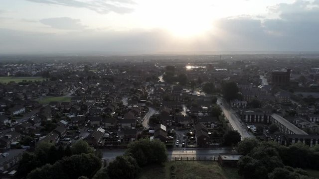 Glowing sunrise over suburban city buildings aerial view at golden hour.