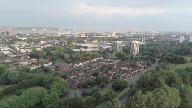 Cityscape coastal shipping docks. Aerial view above city buildings & heavy industry.