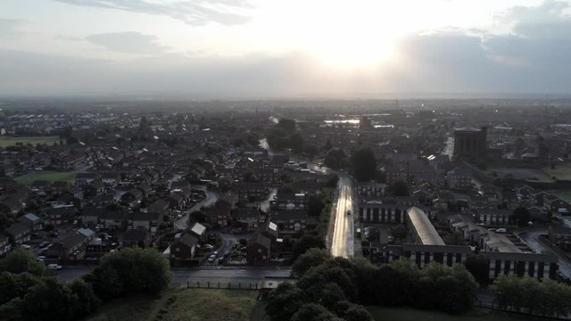 Glowing sunrise over suburban city buildings aerial view at golden hour.