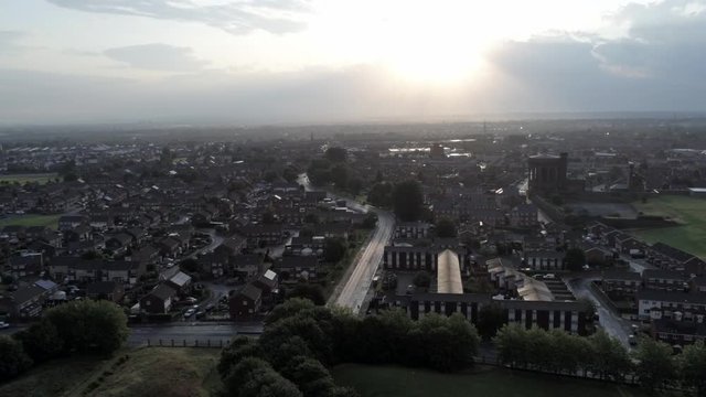 Glowing sunrise over suburban city buildings aerial view at golden hour.