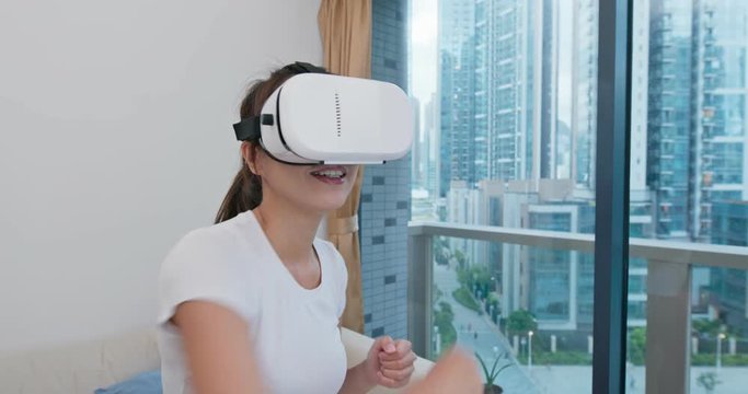 Woman wear VR device and play boxing at home