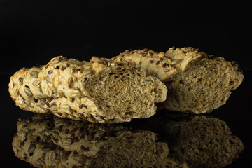 Group of two halves of crispy fresh cereal baguette isolated on black glass