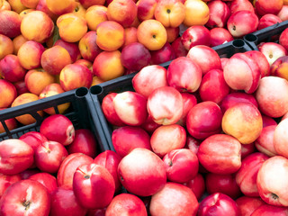Ripe red and yellow peaches, nectarine in the plastic boxes. Food supermarket.