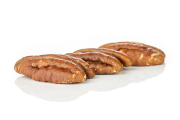 Group of three whole fresh brown pecan nut half in row isolated on white background