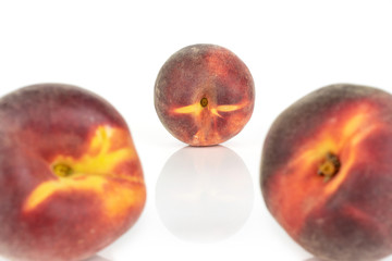 Obraz premium Group of three whole fresh red peach two are in the front, focus is on the one in the back isolated on white background