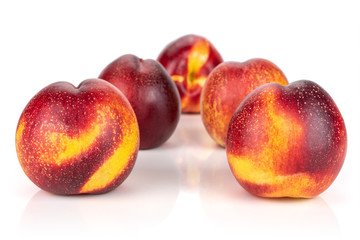 Group of five whole fresh red nectarine layered symmetrically isolated on white background