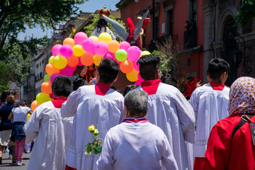 Peregrinación católica con acólitos o monaguillos en una calle de la Ciudad de México