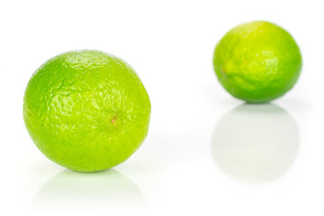 Group of two whole fresh green lime one is in the front isolated on white background