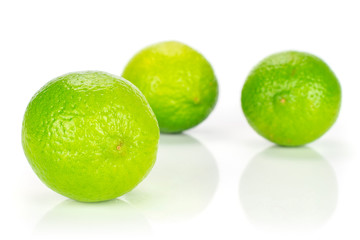 Group of three whole fresh green lime isolated on white background