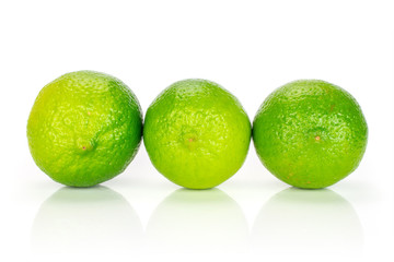 Group of three whole fresh green lime placed in a row isolated on white background