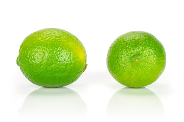 Group of two whole fresh green lime isolated on white background